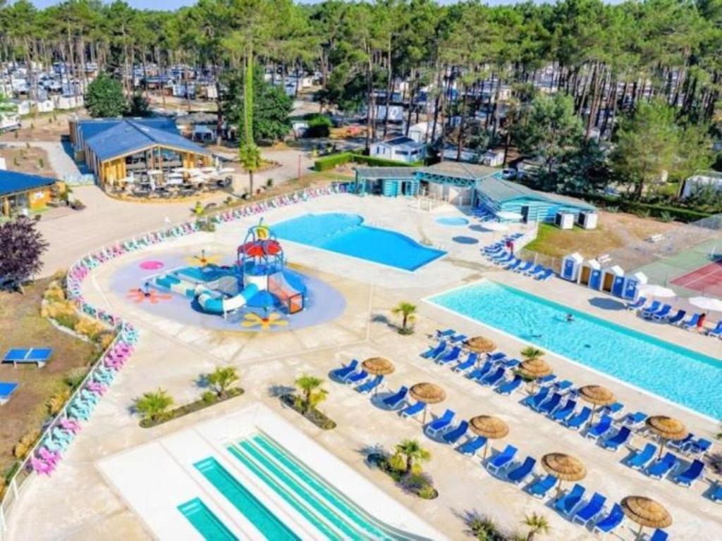une vue aérienne d'une piscine dans un complexe hôtelier dans l'établissement MH 467 Isalisa 3chambres et 1 salle de bain dans camping 4 étoiles avec PARC AQUATIQUE, à Saint-Julien-en-Born