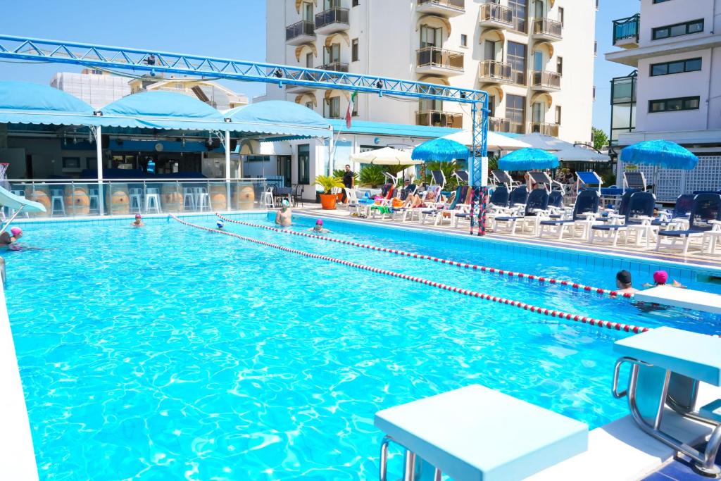 une grande piscine avec des gens dans l'eau dans l'établissement Hotel Tassoni Maison, à Alba Adriatica