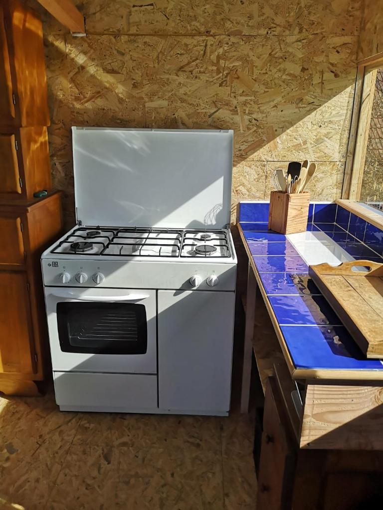 - un four avec plaques de cuisson blanches installé au-dessus d'un comptoir dans l'établissement Sous les Toiles de PauTiLou, à Molles 22 autres photos
