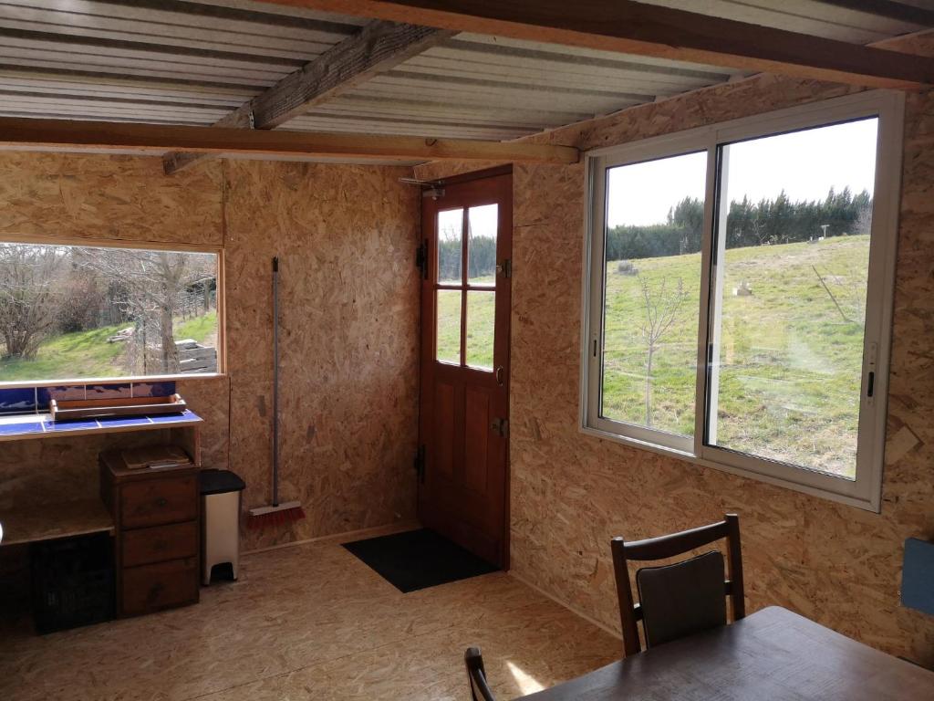 Cette chambre dispose de deux fenêtres, d'un bureau et d'une table. dans l'établissement Sous les Toiles de PauTiLou, à Molles