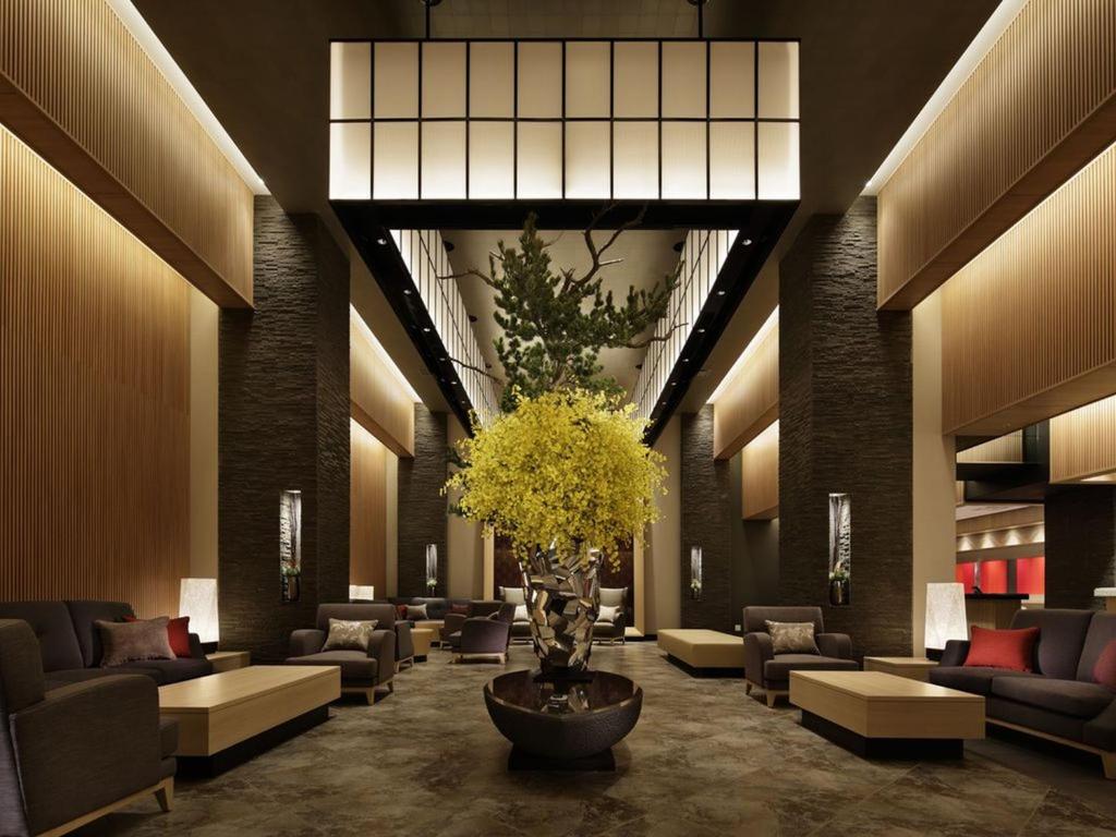un hall avec des canapés et un vase avec une plante dans l'établissement Kobe Minato Onsen Ren, à Kobe