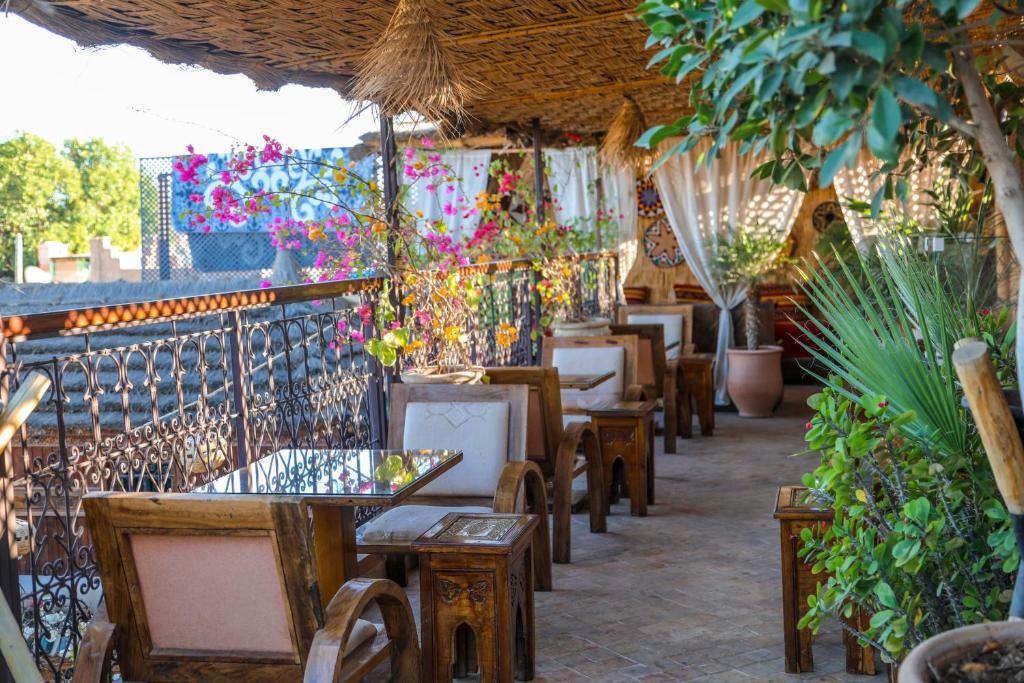 un restaurant avec des tables, des chaises et des plantes en pot dans l'établissement Riad Melhoun & Spa, à Marrakech