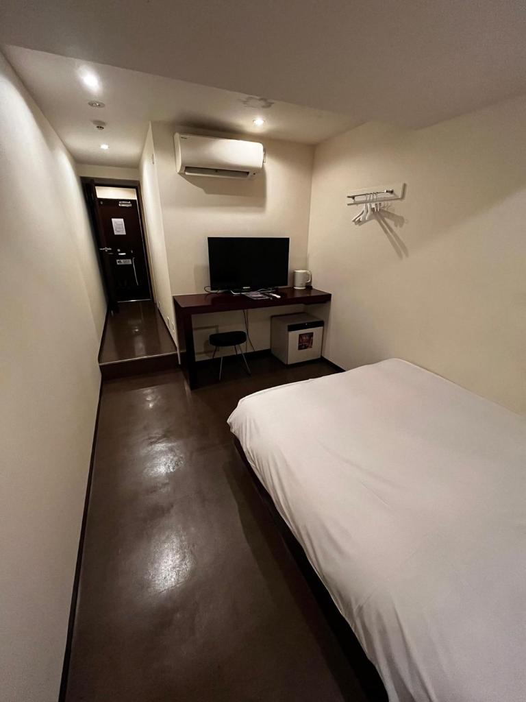 une chambre avec un lit et un bureau avec un ordinateur dans l'établissement Hills Hotel Gotanda, à Tokyo