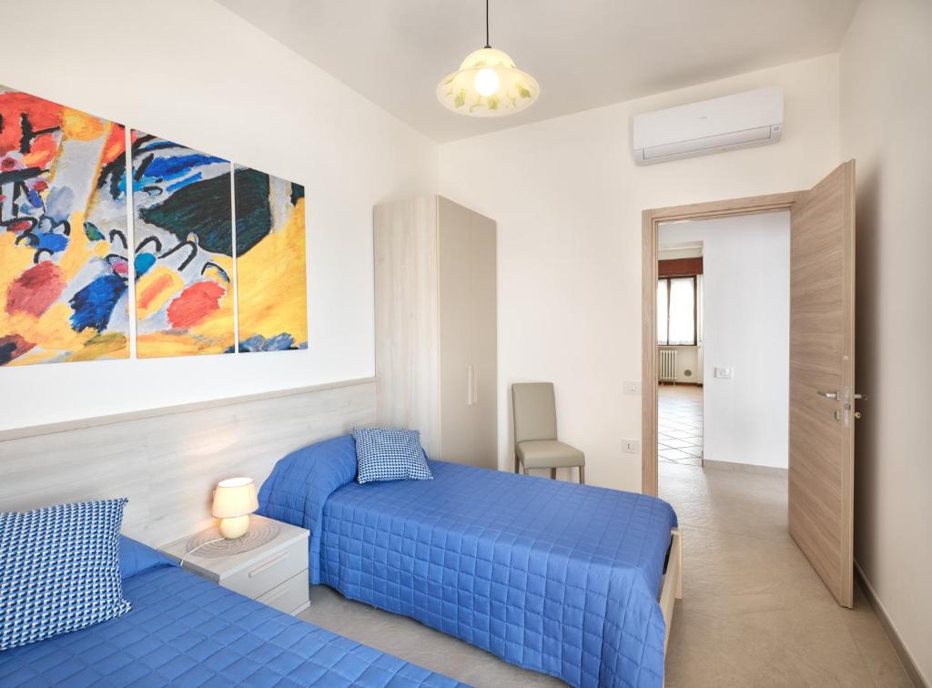 une chambre avec deux lits et un tableau au mur dans l'établissement VILLA HARMONY - Regarda Travel, à Lazise