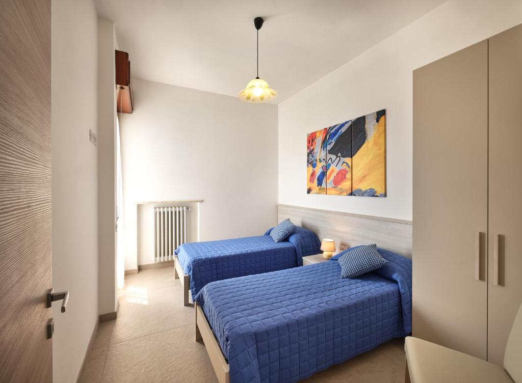 - 2 lits dans une chambre avec des draps bleus dans l'établissement VILLA HARMONY - Regarda Travel, à Lazise 48 autres photos