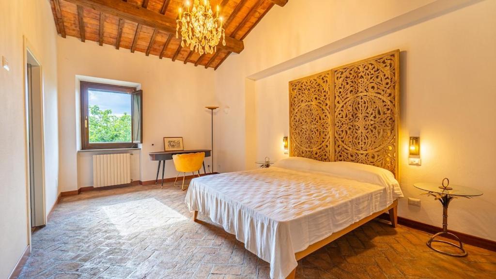 une chambre avec un lit et un lustre dans l'établissement Villa La Spina, à San Lorenzo Nuovo