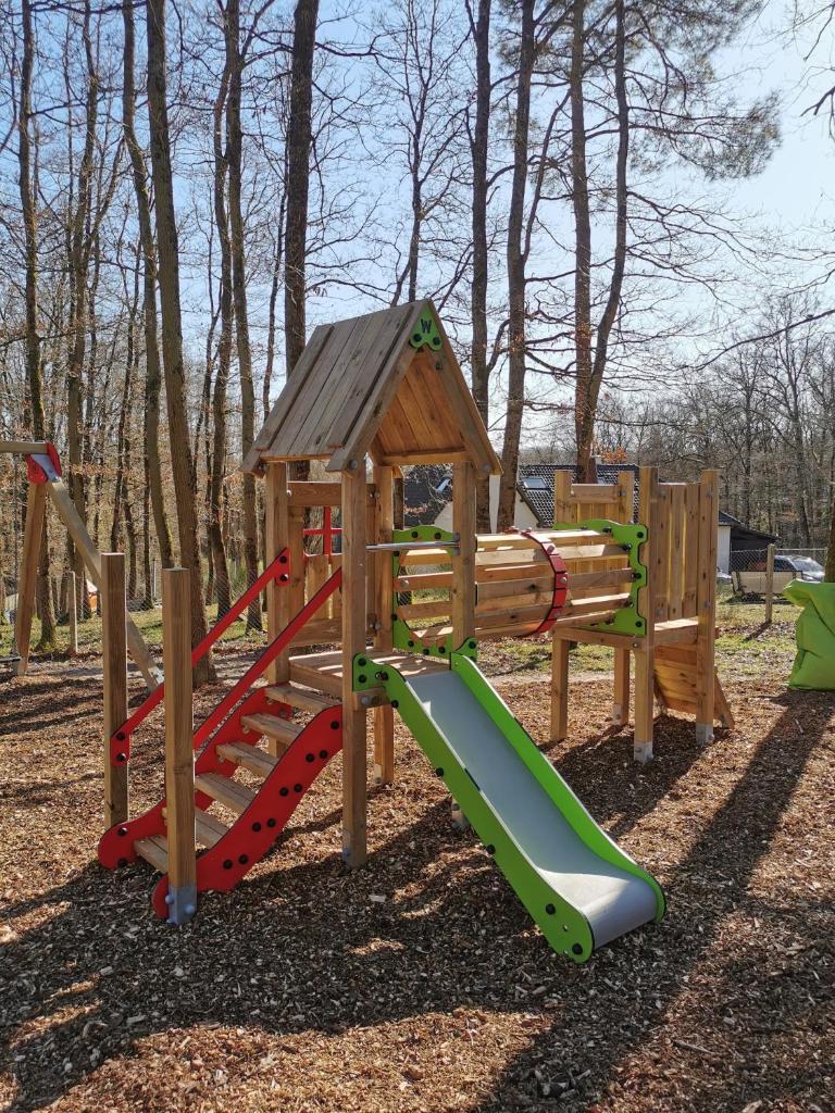 une aire de jeux en bois avec toboggan et structure de jeu dans l'établissement La Parenthèse Meslandaise, à Mesland