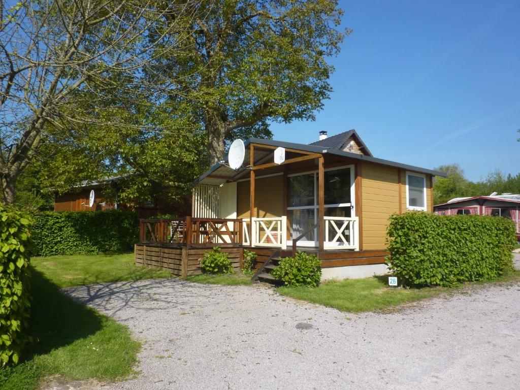 une petite maison jaune avec une grande véranda dans l'établissement Camping Pommiers des Trois Pays, à Licques