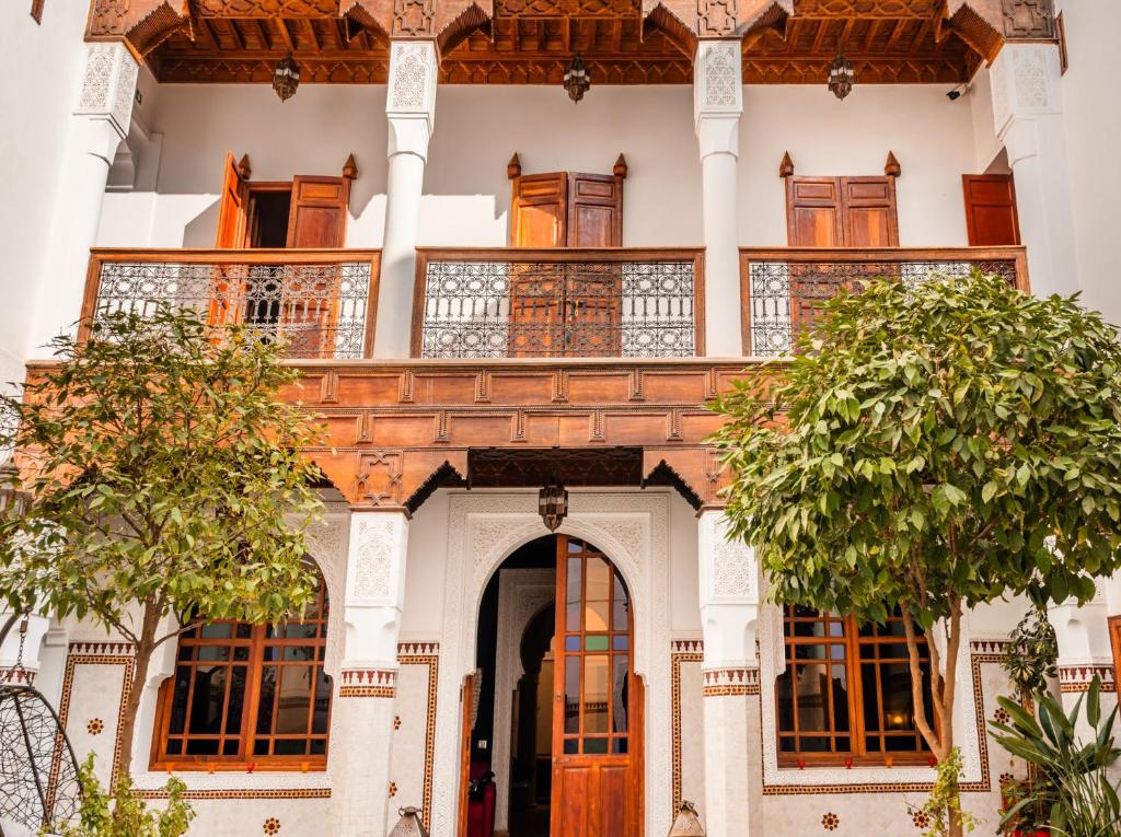 un bâtiment avec un balcon et des arbres devant lui dans l'établissement Ysalis Riad Restaurant & Spa, à Marrakech