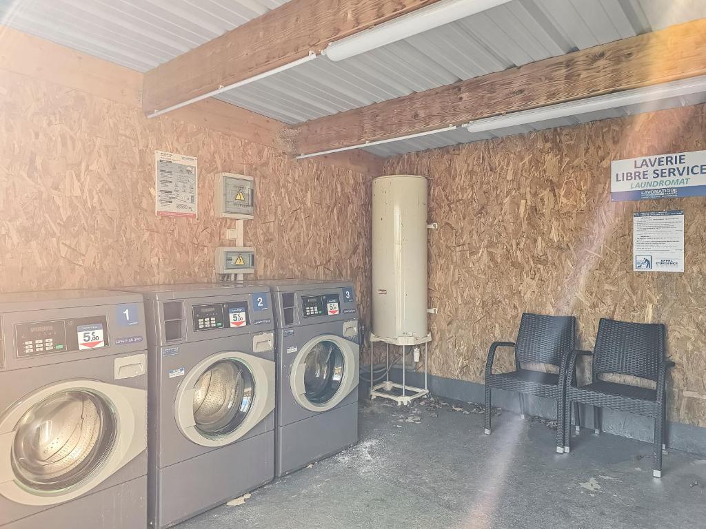 - une buanderie avec 2 lave-linge et 2 chaises dans l'établissement Mobile Home Luca - Séjour Nature, à Litteau