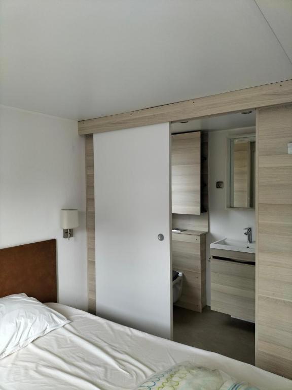 - une chambre avec un lit et une salle de bains avec un miroir dans l'établissement Camping, au Muy