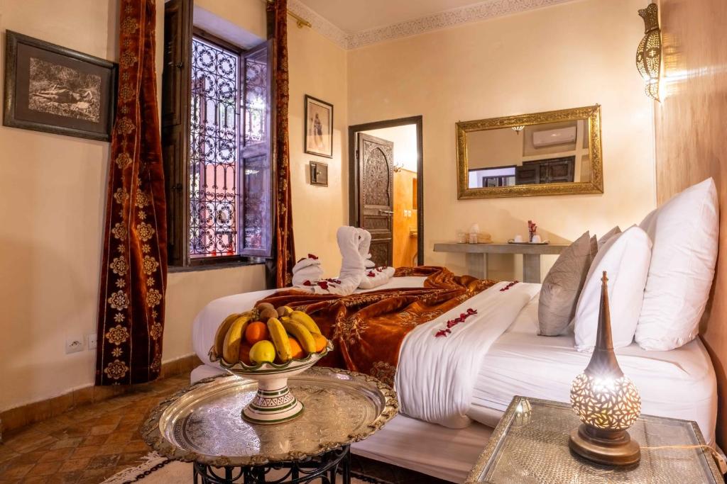 - une chambre avec un lit et un bol de bananes sur une table dans l'établissement Riad Alaka, à Marrakech