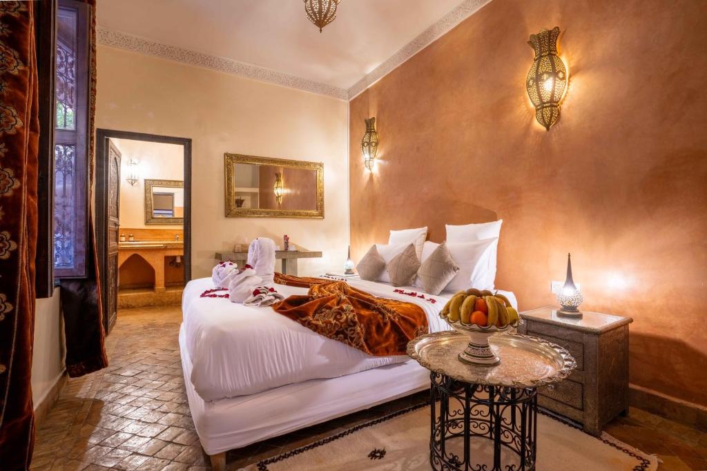 une chambre avec un lit et une table avec un bol de fruits dans l'établissement Riad Alaka, à Marrakech