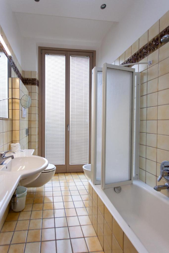 une salle de bain avec une baignoire, un lavabo et une douche dans l'établissement Hotel Flaminia, à Sirmione 74 autres photos