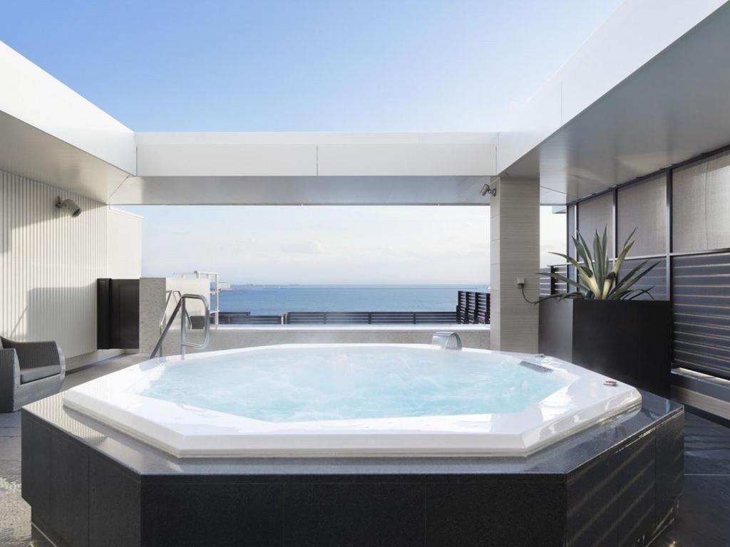Cette chambre dispose d'une grande baignoire et offre une vue sur l'océan. dans l'établissement Kobe Minato Onsen Ren, à Kobe
