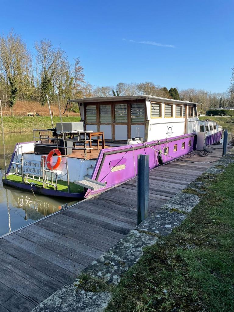 un bateau rose est amarré à côté d'un quai dans l'établissement Nuit insolite à bord d'une péniche, 6 personnes, à Bergues