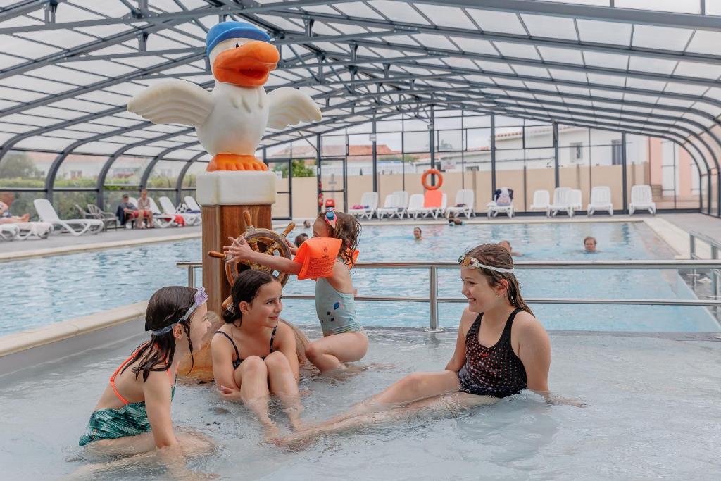 - un groupe de filles assises dans une piscine dans l'établissement Camping Cabestan, à Bretignolles-sur-Mer