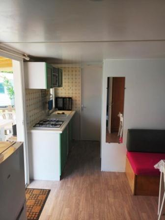 une petite cuisine avec des placards verts et une cuisinière blanche dans l'établissement Mobil home LA BAULE 437, à La Baule