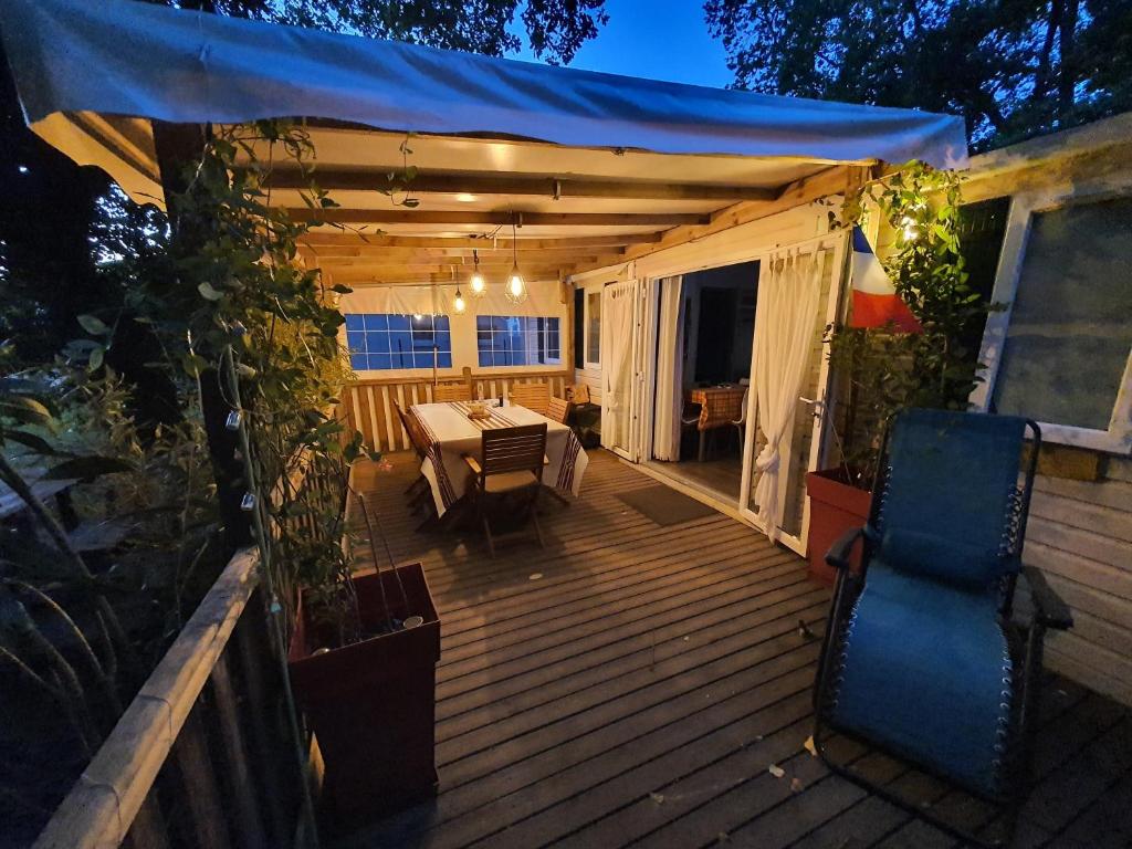 une terrasse avec une table et des chaises. dans l'établissement Mobil-home 3 chambres climatisé sur le domaine 4 étoiles Rivages des Landes, à Aureilhan