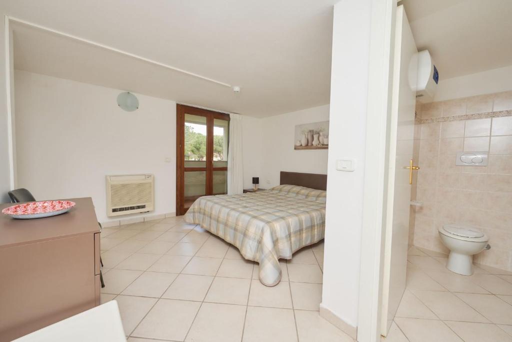 une chambre avec un lit et une salle de bain avec WC dans l'établissement Pineta Azzurra, à Marina di Grosseto