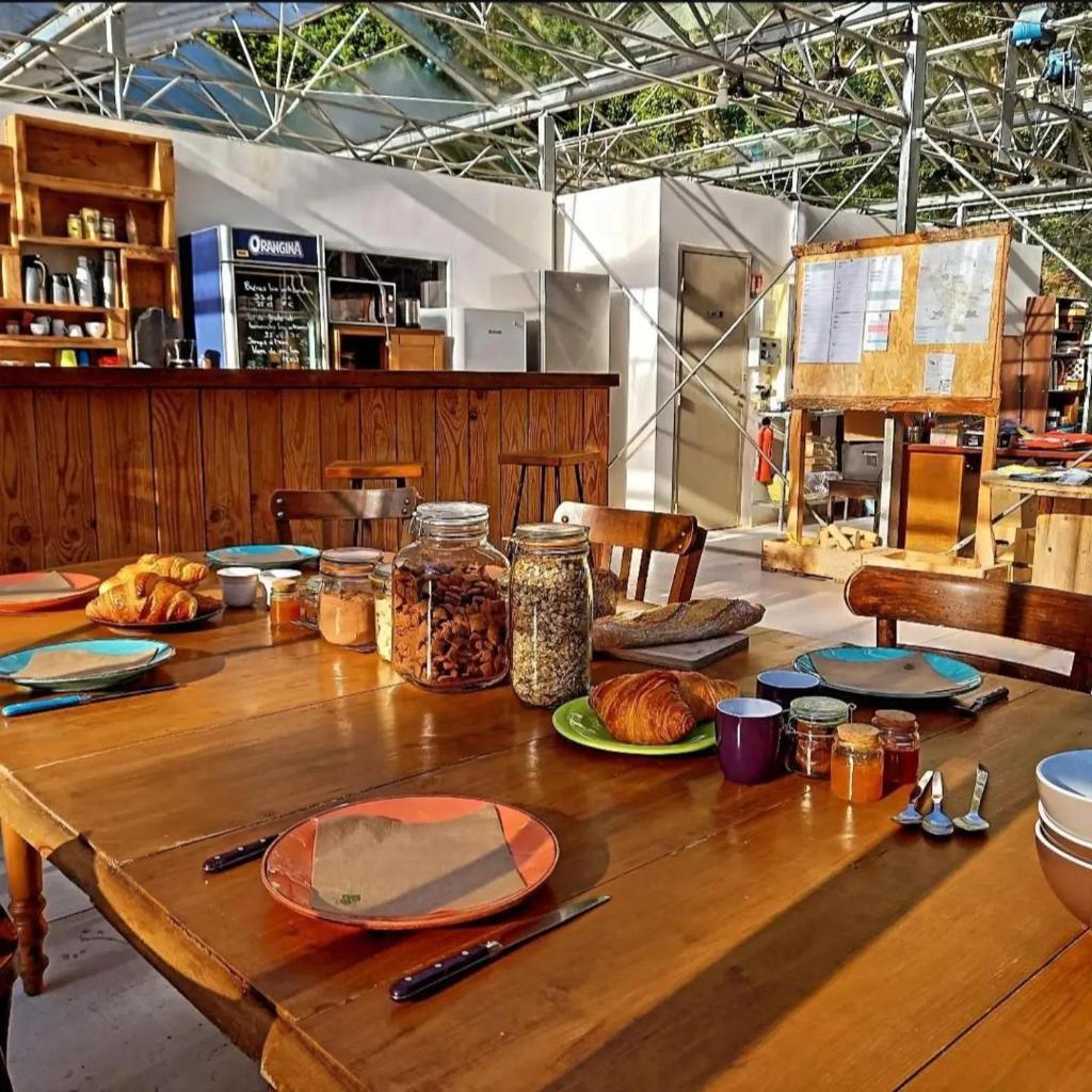 une table en bois avec des assiettes de nourriture dessus dans l'établissement Camping Terre Rouge, à Villecomtal