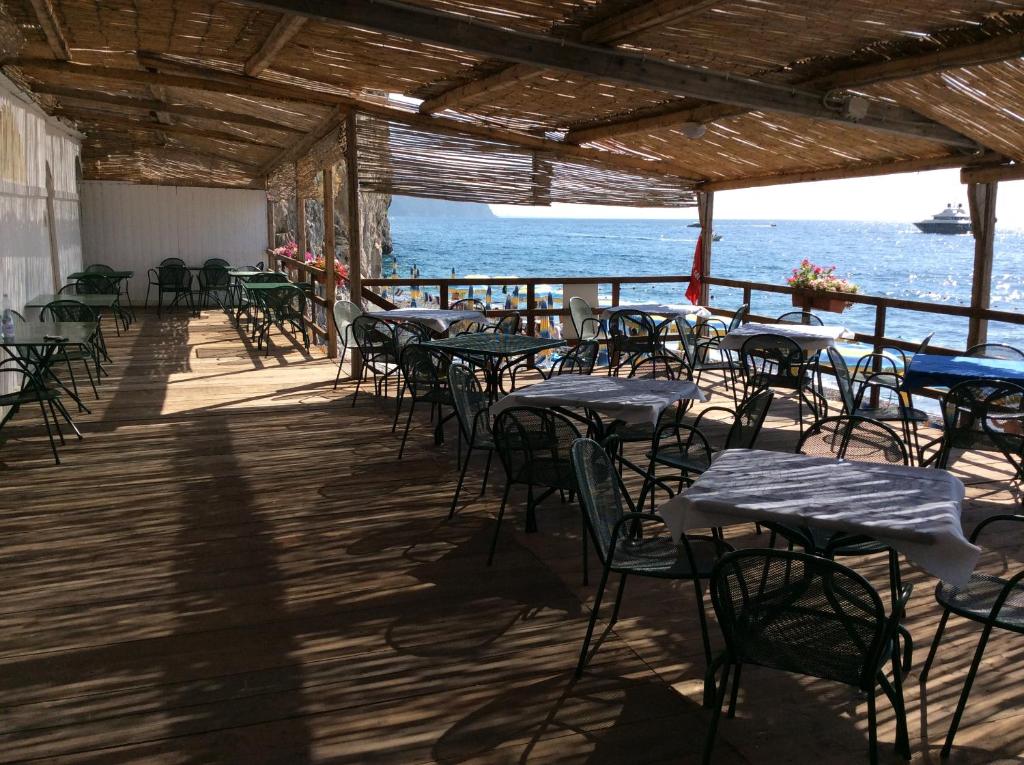 une rangée de tables et de chaises sur une terrasse donnant sur l'océan dans l'établissement Grand Hotel Excelsior, à Amalfi