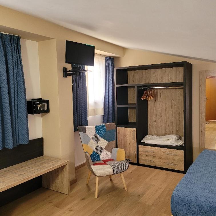 une pièce avec un lit et une chaise et une chambre à coucher dans l'établissement Hotel Eden Sul Lago, à Bolsena