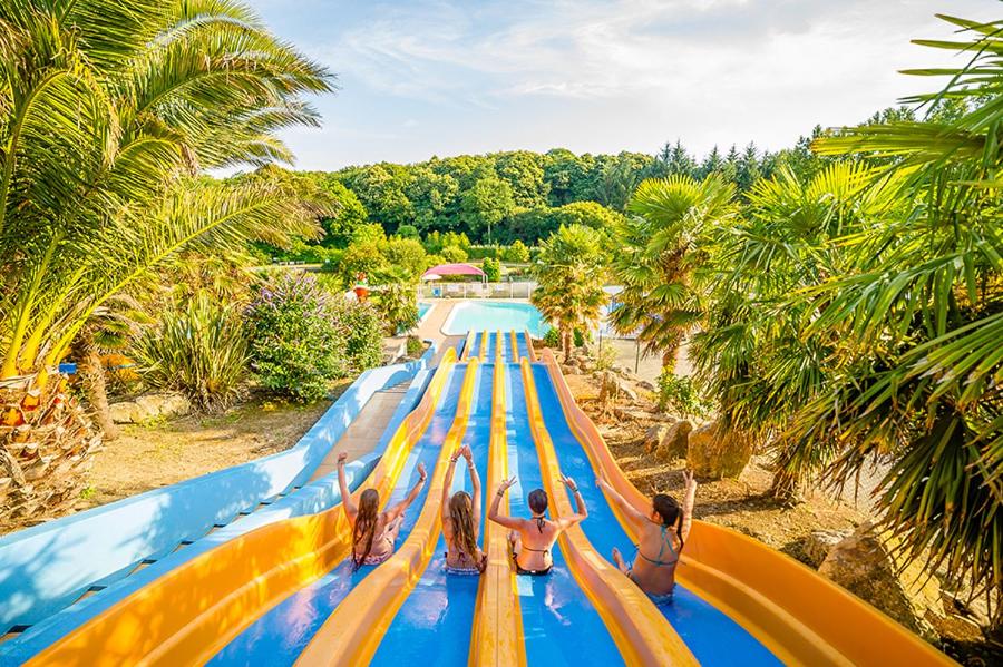 un groupe de personnes sur un toboggan aquatique dans un parc à thème dans l'établissement Camping Paradis Domaine de Bel Air, à Landudec