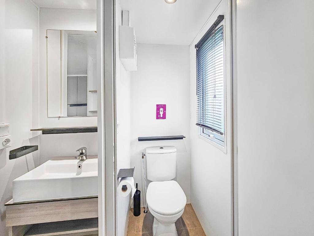 une salle de bain blanche avec des toilettes et un lavabo dans l'établissement Le Nocia, à Litteau 17 autres photos