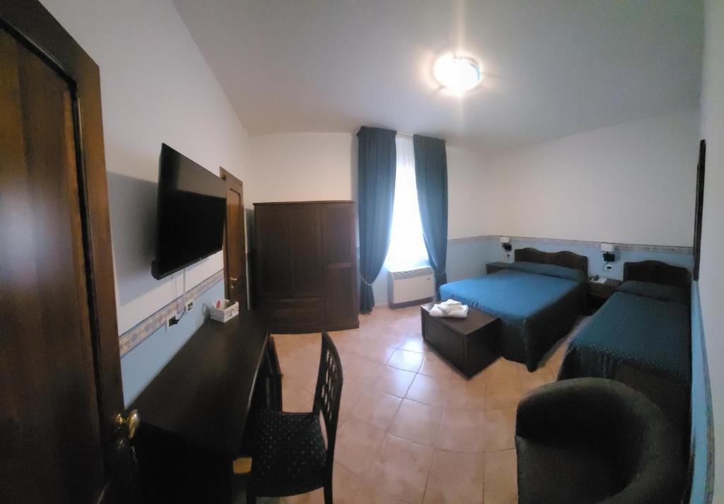 - un salon avec un lit bleu et un canapé dans l'établissement Hotel Eden Sul Lago, à Bolsena