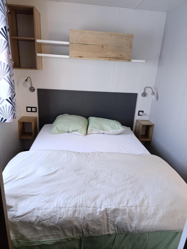 un lit dans une chambre avec deux oreillers dessus dans l'établissement Camping Siblu Le Montourey, à Fréjus