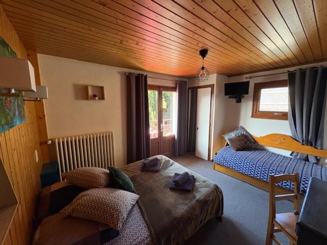 une chambre avec un lit et un canapé dans une pièce dans l'établissement Le Rookie Mountain, au Grand-Bornand