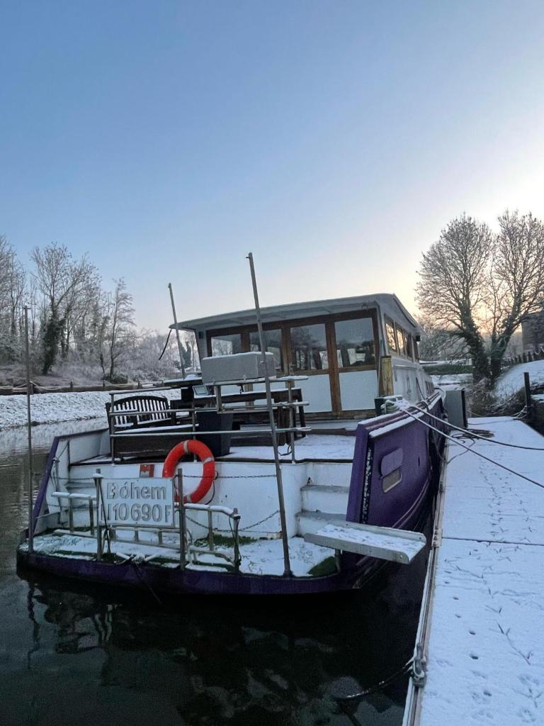 un bateau est amarré dans l'eau dans la neige dans l'établissement Nuit insolite à bord d'une péniche, 6 personnes, à Bergues