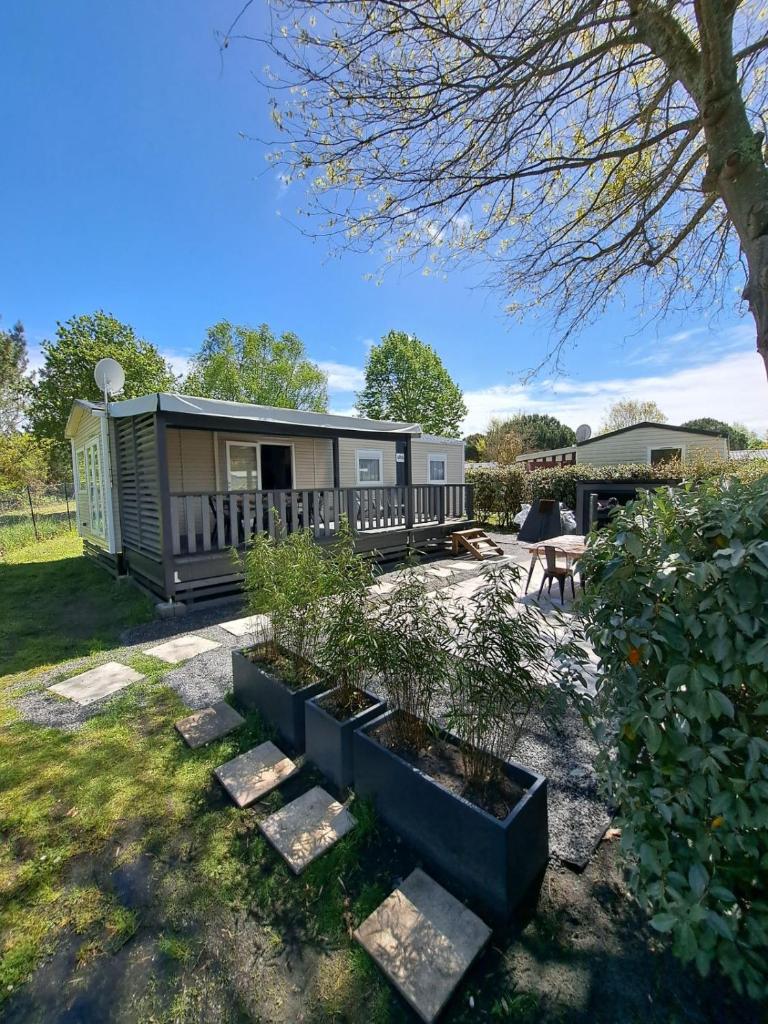 Cette petite maison dispose d'une terrasse couverte. dans l'établissement Le Cozy'Land - Mobilhome Camping La Réserve, à Gastes