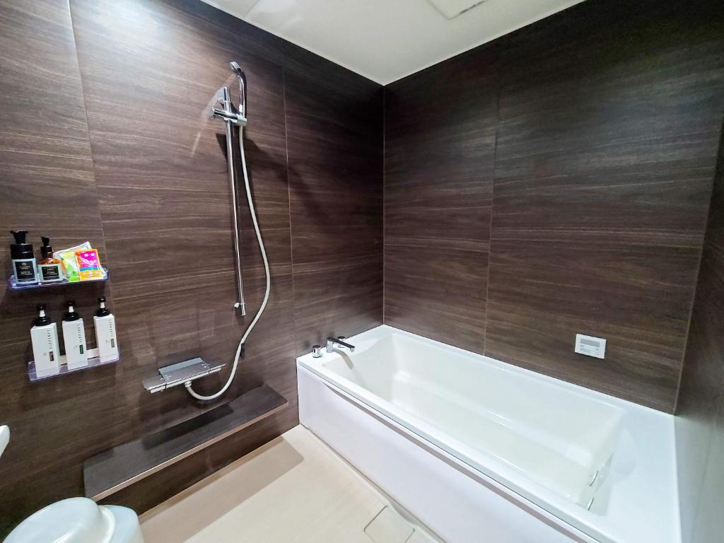 une salle de bain avec une baignoire blanche et une douche dans l'établissement Pal Annex Katsuyama (Love Hotel), à Miyakomachi 25 autres photos