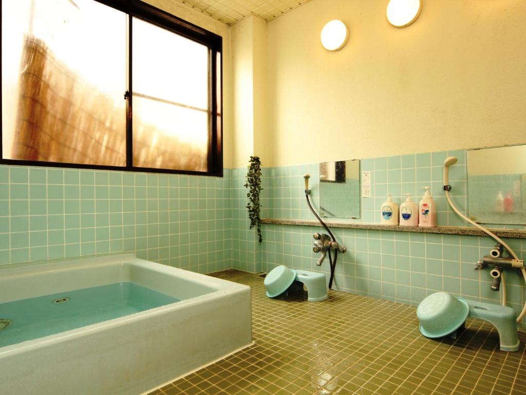 une salle de bain avec une baignoire, des toilettes et un lavabo dans l'établissement Hatoguruma Kawabata, à Nozawa Onsen 37 autres photos