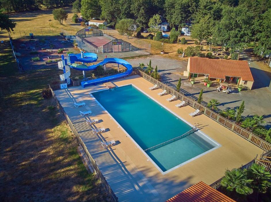 Elle offre une vue sur la grande piscine bordée de chaises. dans l'établissement PuyduFou MH F4 FULL CONFORT 6personnes 220FS, à La Boissière-de-Montaigu
