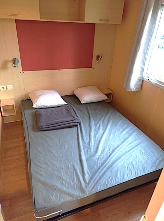Cette petite chambre comprend un lit dans une chambre dotée d'une fenêtre. dans l'établissement PuyduFou MH F4 FULL CONFORT 6personnes 220FS, à La Boissière-de-Montaigu