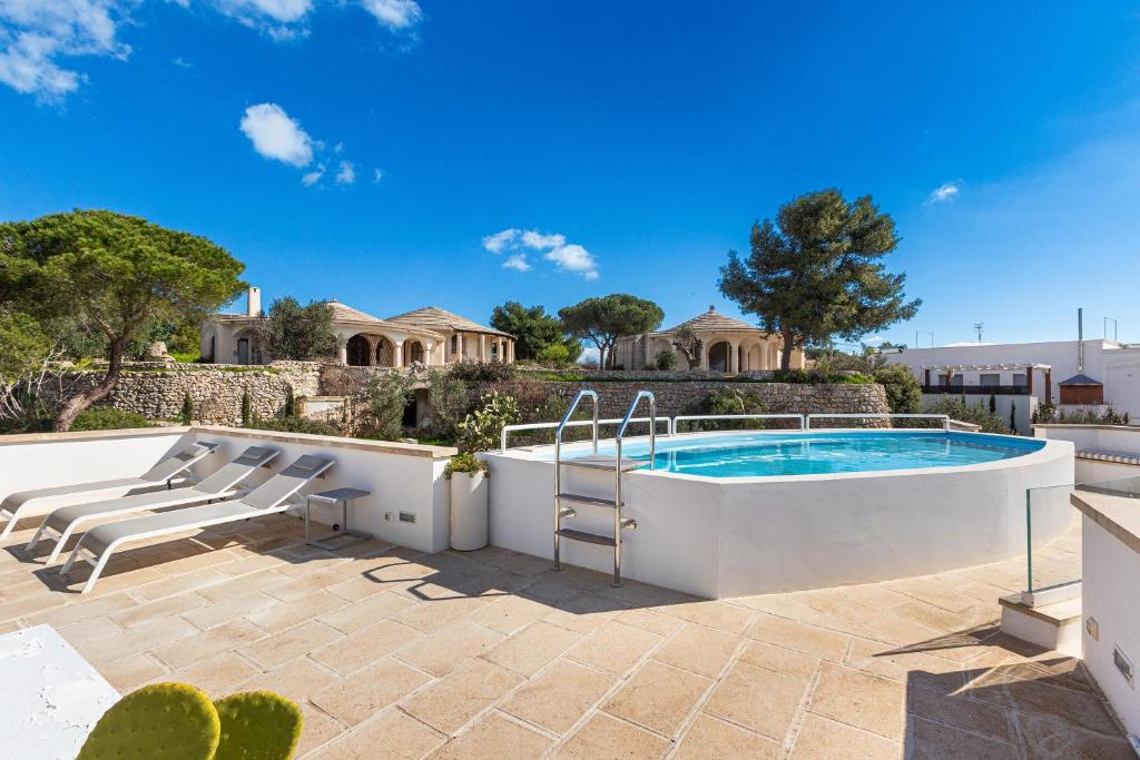 - une piscine dans une terrasse avec des chaises et une maison dans l'établissement Villa Horus by Perle di Puglia, à Leuca