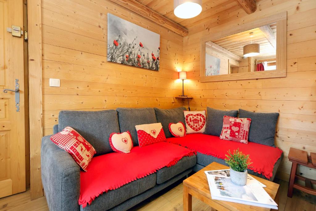 un salon avec un canapé gris avec des coussins rouges dans l'établissement la levanna, à Les Deux Alpes