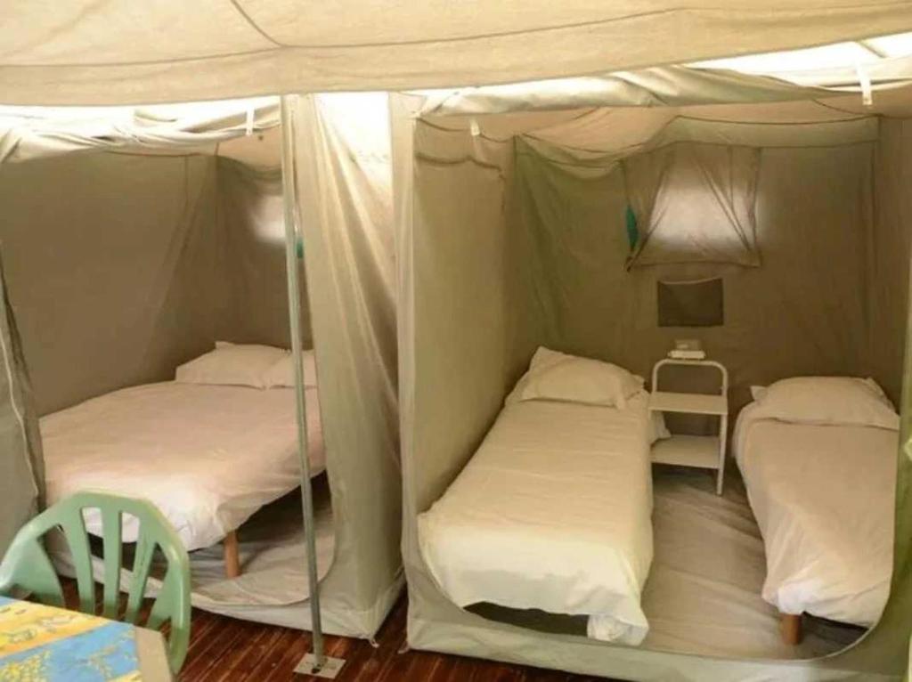 Ce dortoir comprend 2 lits superposés et une table. dans l'établissement Camping 3 étoiles - Piscine - cbgcaia, à Buis-les-Baronnies