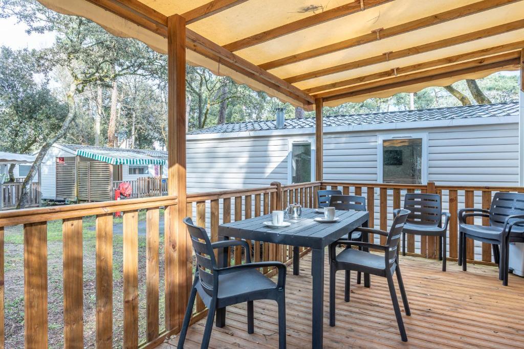 un patio avec une table et des chaises sur une terrasse dans l'établissement Mobil Home 150, à Longeville-sur-Mer