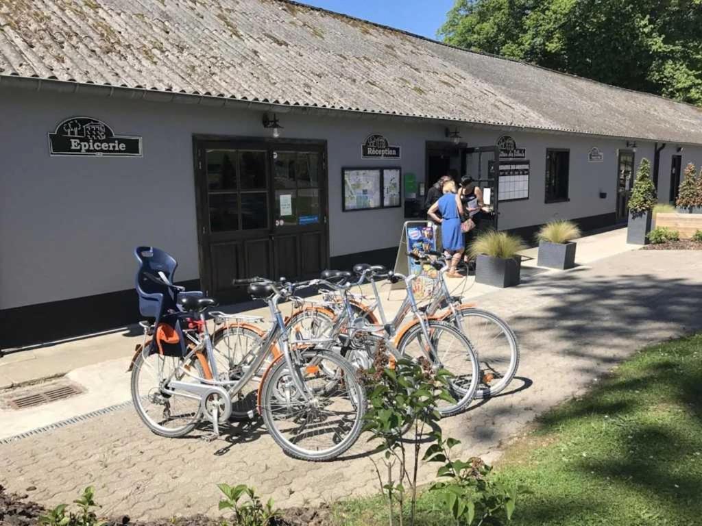un groupe de vélos garés à l'extérieur d'un bâtiment dans l'établissement Camping 3 étoiles - Piscine - ccbaeei, à Grand-Laviers