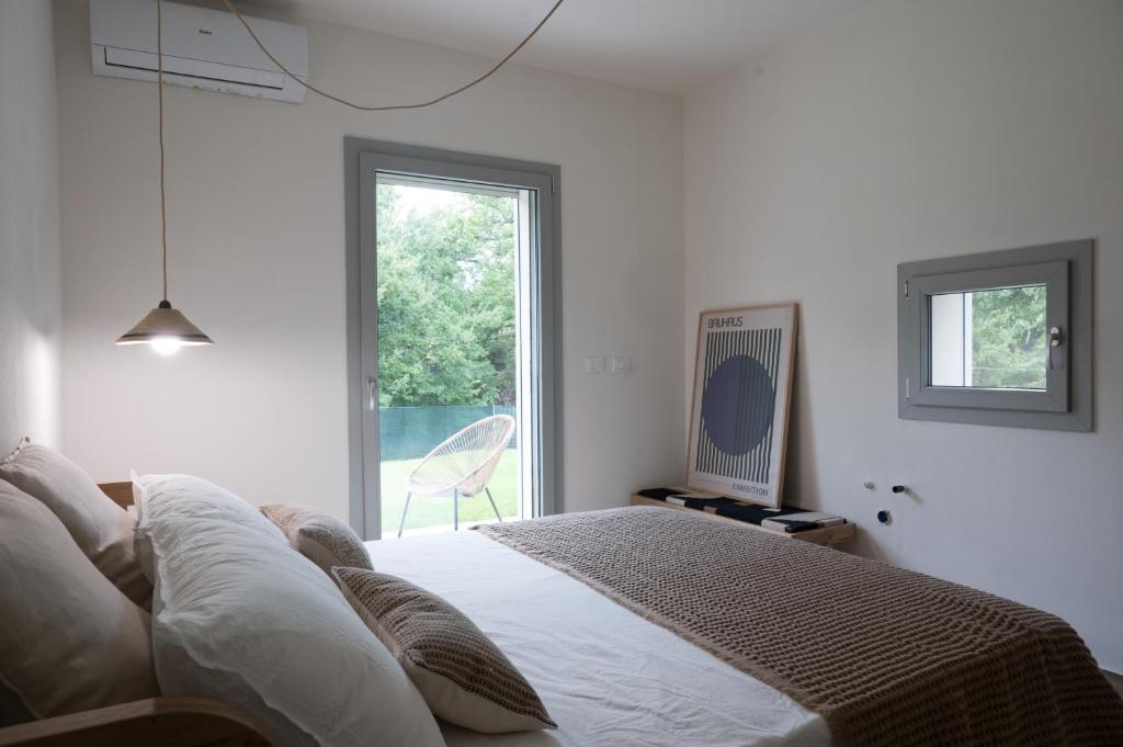 une chambre blanche avec un lit et une fenêtre dans l'établissement Villa La Leccina a Castellina Marittima, à Castellina Marittima