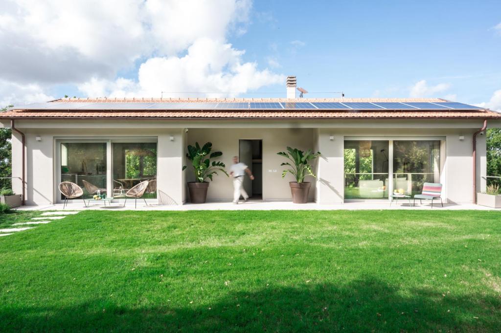 une maison avec une pelouse devant dans l'établissement Villa La Leccina a Castellina Marittima, à Castellina Marittima