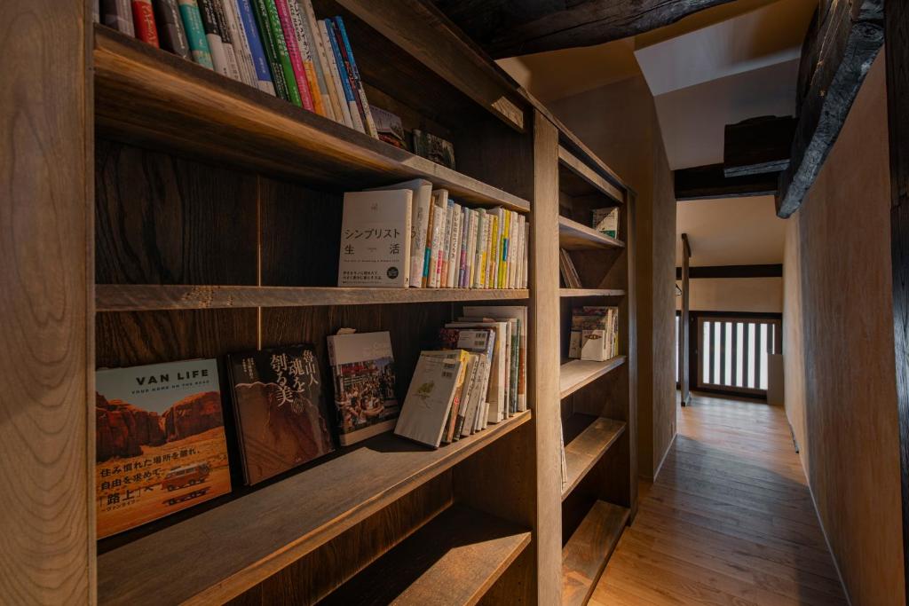 une étagère remplie de livres dans une pièce dans l'établissement Onsen and Garden Nana, à Kanazawa