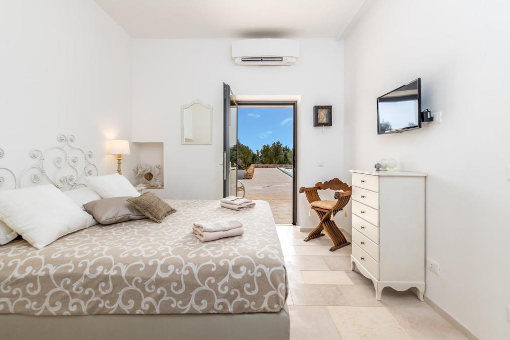 une chambre avec un grand lit et une commode dans l'établissement LA CORTE BIANCA LUXURY VILLA, à Ostuni 38 autres photos