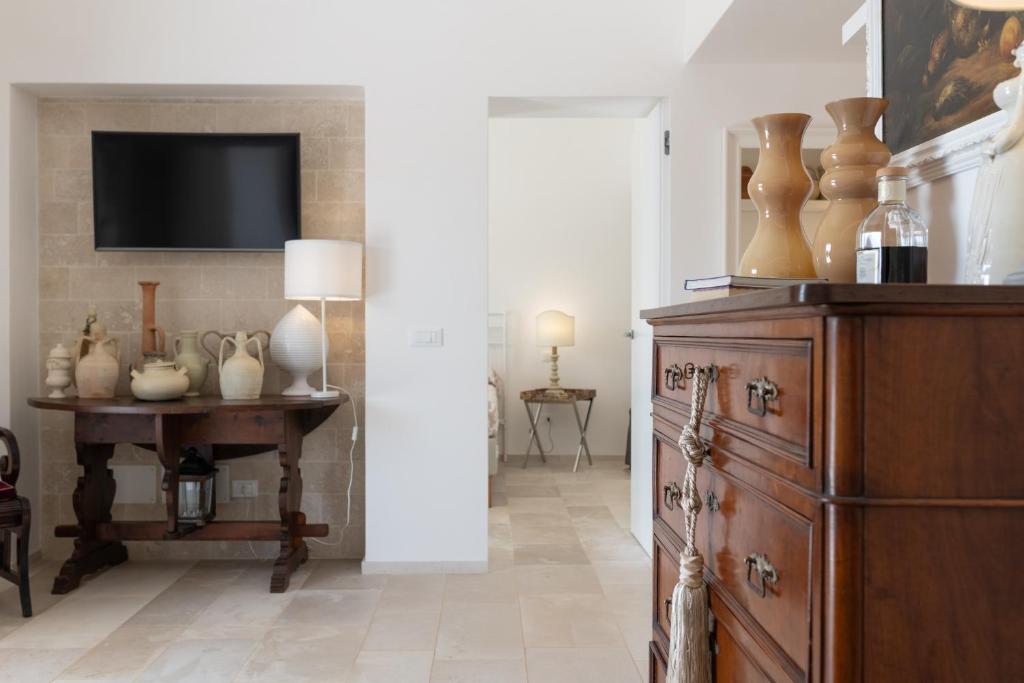 une pièce avec une commode et une table avec des vases dessus dans l'établissement LA CORTE BIANCA LUXURY VILLA, à Ostuni