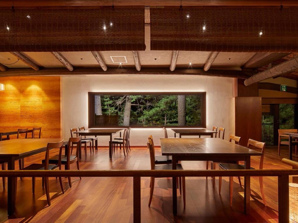 une salle à manger avec tables et chaises et une grande fenêtre dans l'établissement Hotel Kinparo, à Toyooka 52 autres photos