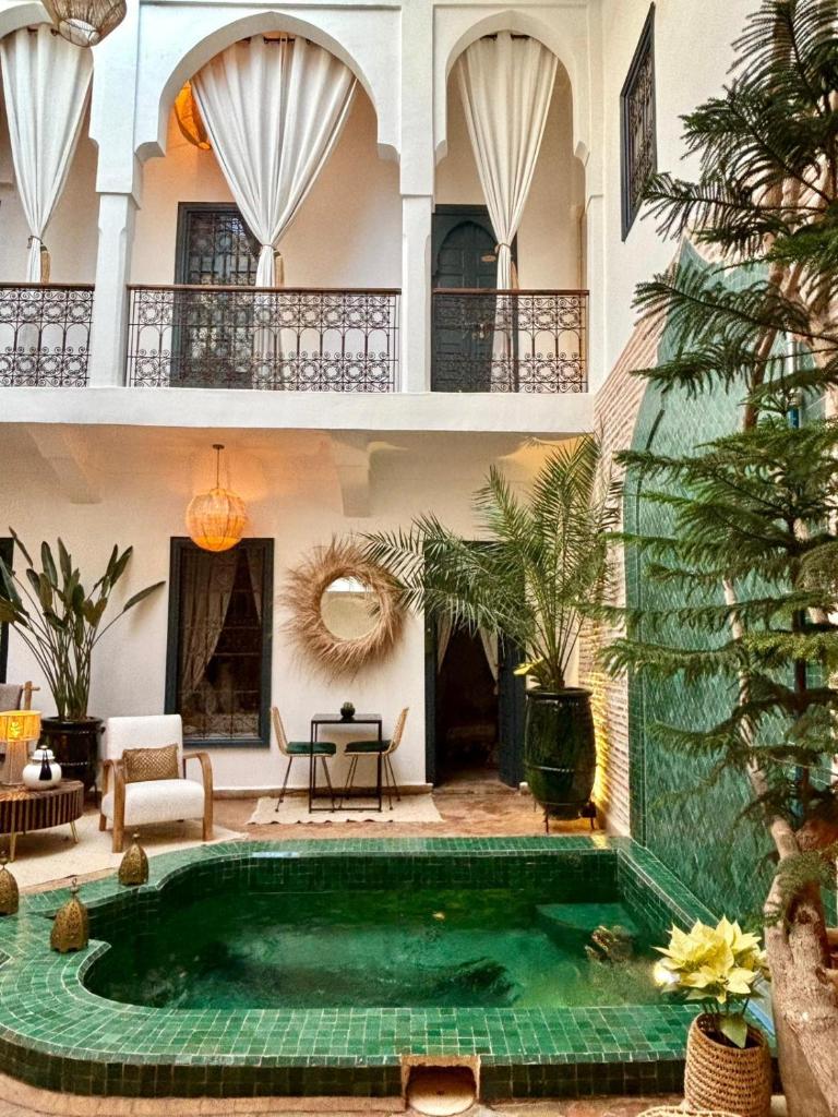 une piscine au milieu d'un immeuble avec une maison dans l'établissement Riad Dar Marrakcha, à Marrakech